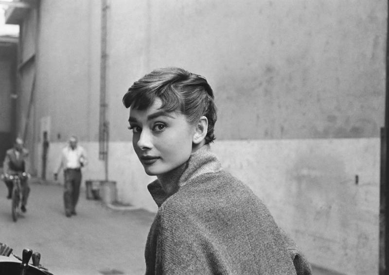 Mark Shaw Mark Shaw AUDREY HEPBURN IN GREY TURTLENECK SWEATER GLANCES BACK 1953